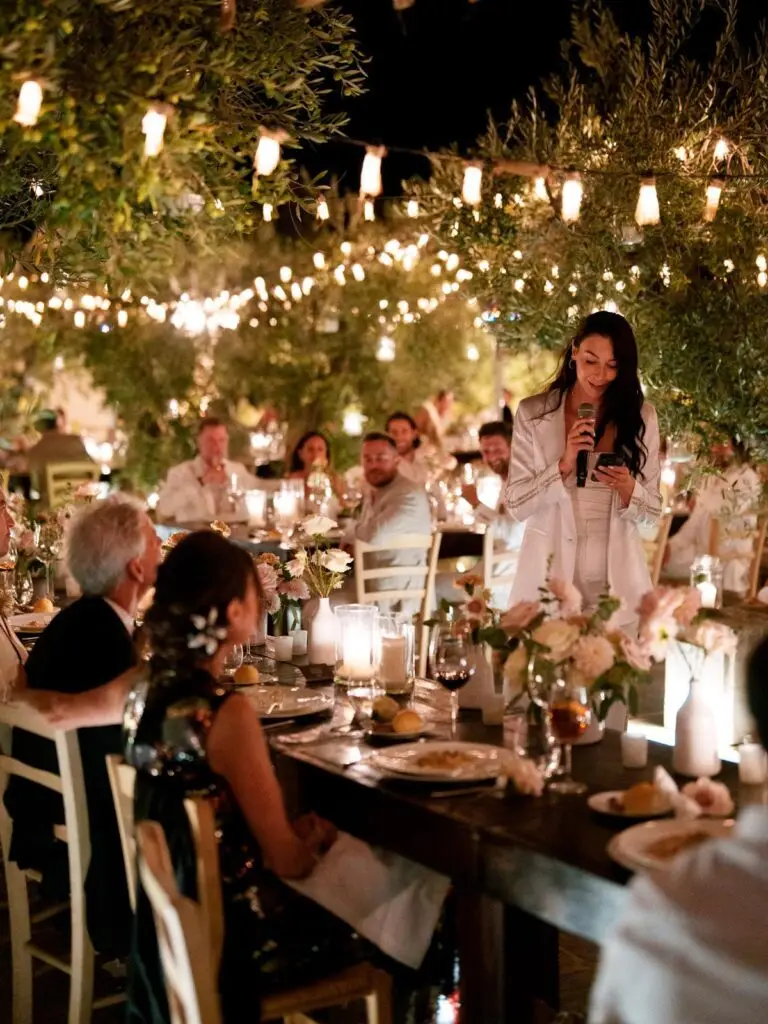 Bride giving a speech at a candlelit wedding dinner in Puglia