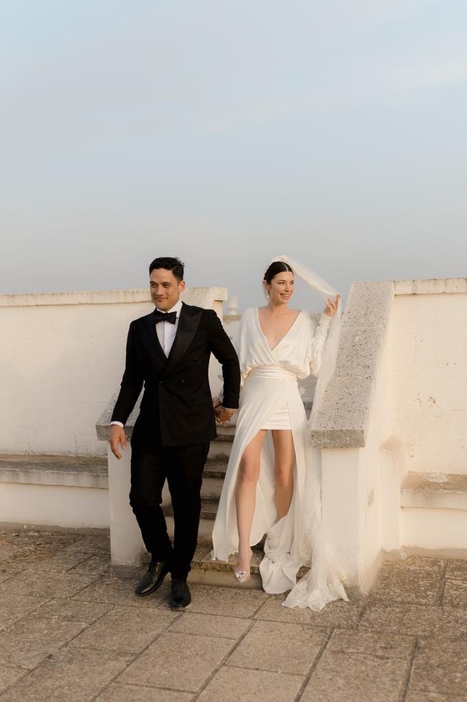 Newly married couple walking through white Puglia architecture
